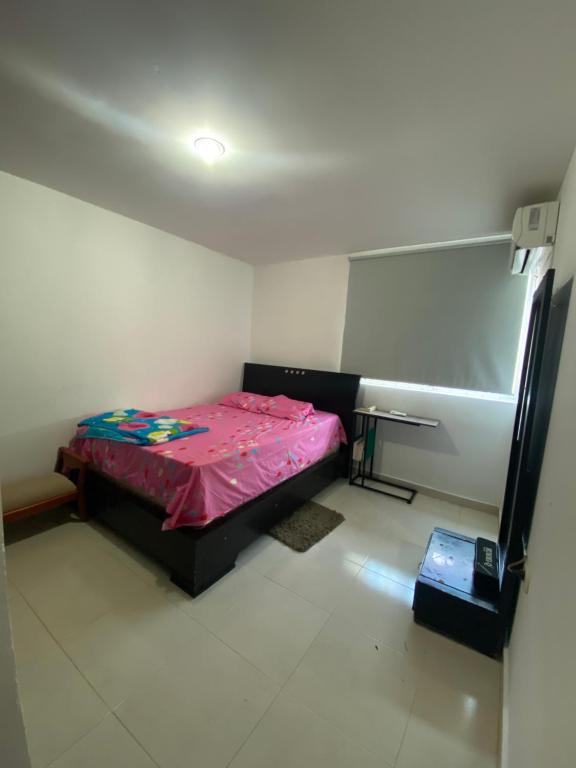 een kleine kamer met een bed en een wastafel bij Don carmelo in Valledupar