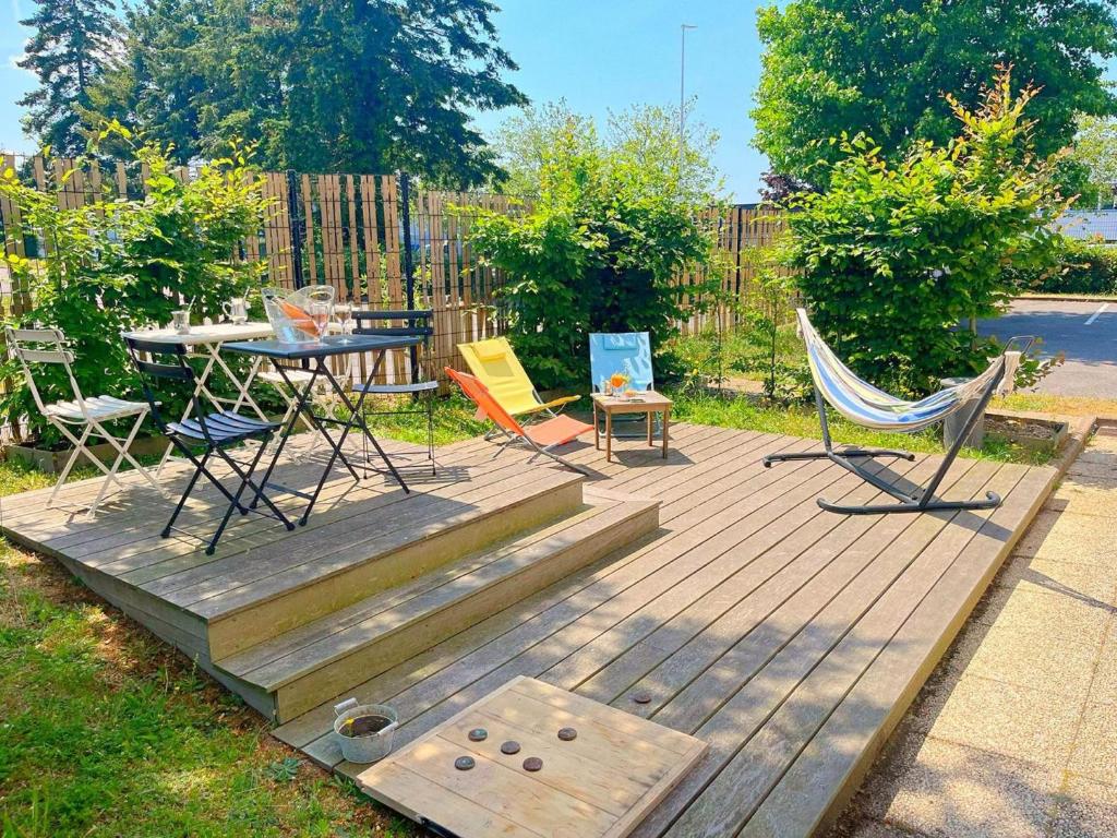 una terrazza in legno con sedie, tavolo e tavolo di ibis Nantes Saint Herblain a Saint-Herblain