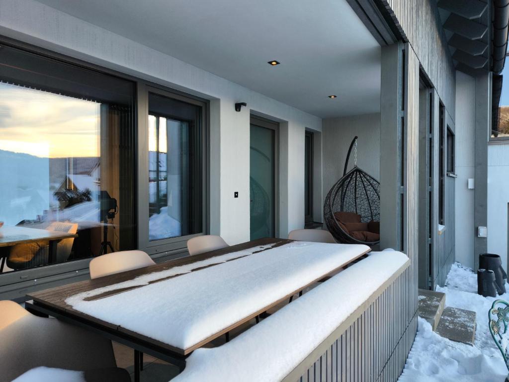 溫特貝格的住宿－SAUERLAND CHALETS - "Die Chalets Herzenssache"，阳台上的一张床上,上面有雪