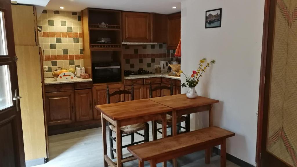 eine Küche mit Holzschränken und einem Holztisch in der Unterkunft La Cirerole in Casteil