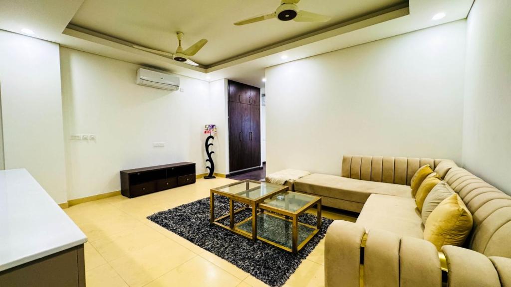 ein Wohnzimmer mit einem Sofa und einem Tisch in der Unterkunft Eighteen Islamabad in Islamabad