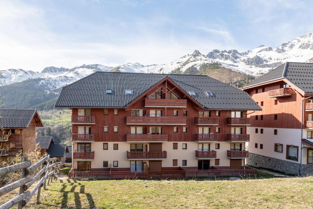 a building with snow covered mountains in the background at Appartement St François Longchamp in Saint-François-Longchamp