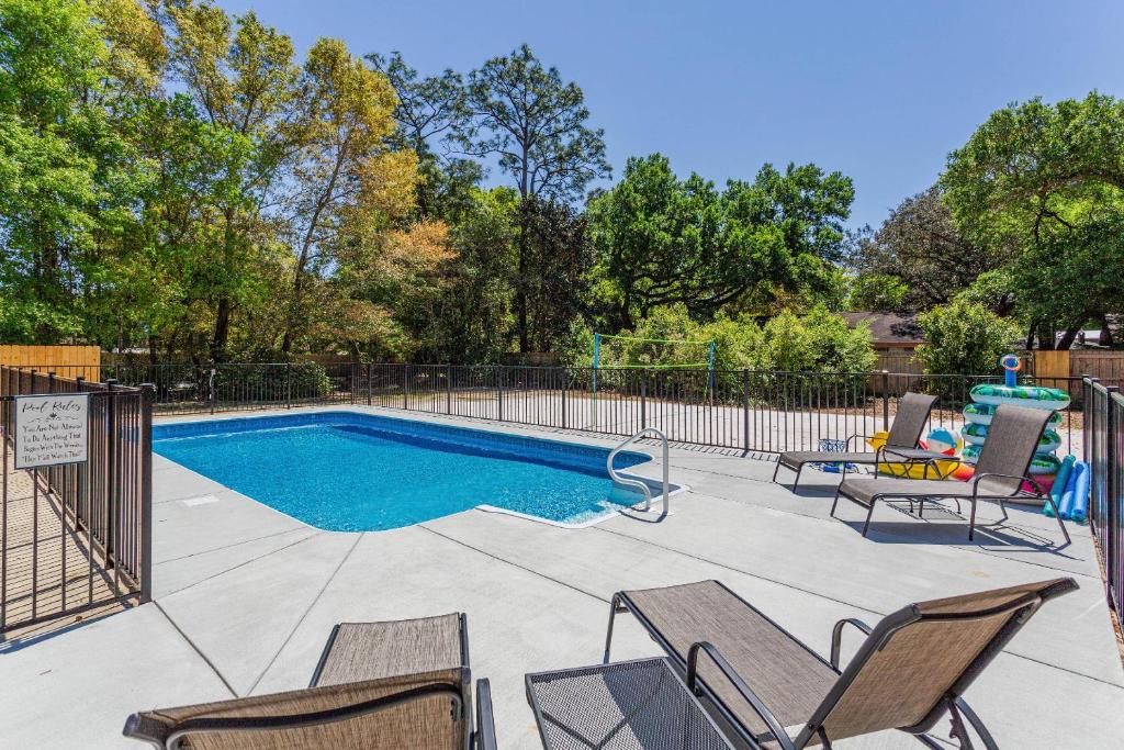 a swimming pool with chairs and a fence at 2967 Swan Lane in Pensacola