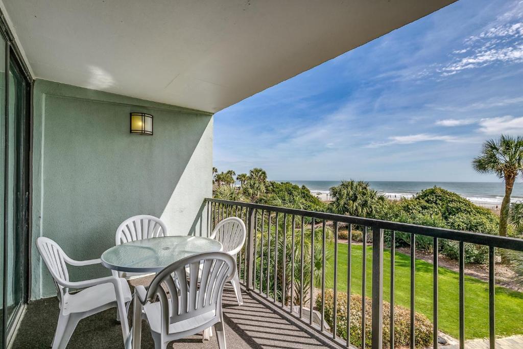 een balkon met een tafel en stoelen en de oceaan bij Carolina Dunes 104 in Myrtle Beach