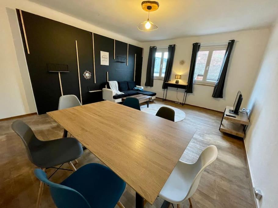 ein Wohnzimmer mit einem Holztisch und Stühlen in der Unterkunft Appartements « La Parenthèse » in Wissembourg