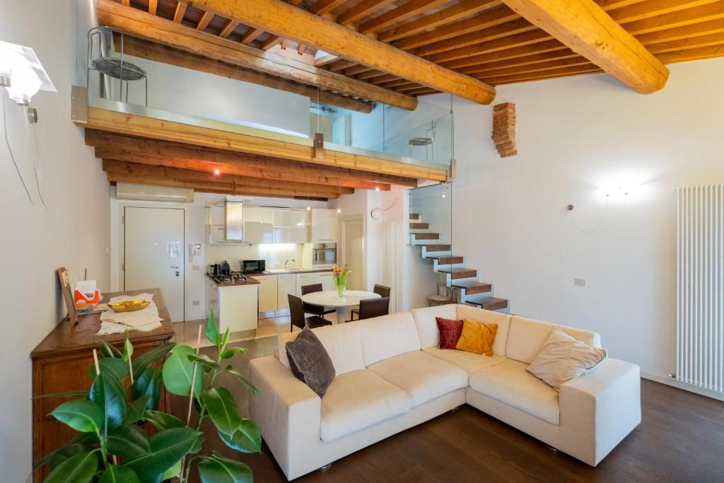 ein Wohnzimmer mit einer weißen Couch und einer Treppe in der Unterkunft Appartamento Stella - Verona Centro in Verona