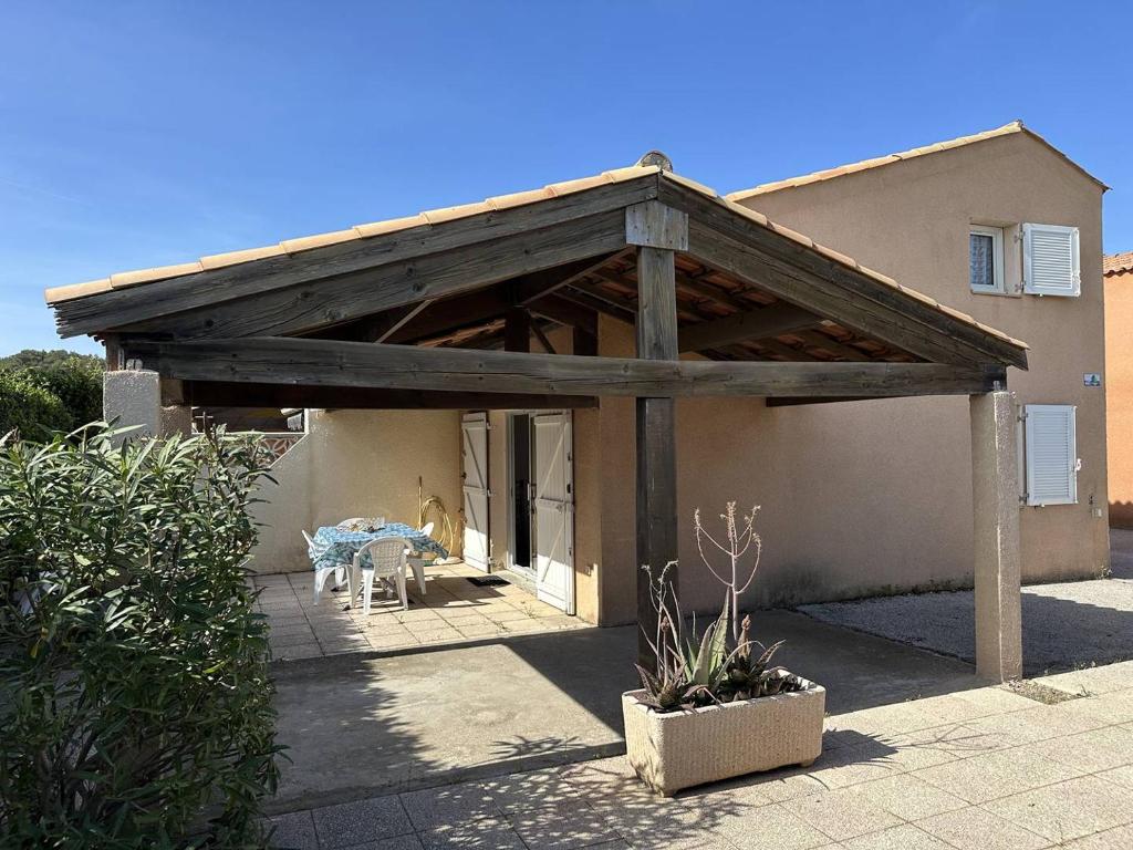 une terrasse avec une pergola en bois sur une maison dans l'établissement HOLIDAYLAND 137 VILLA T3 MEZZANINE 7 couchages climatisé NARBONNE PLAGE, à Narbonne-Plage