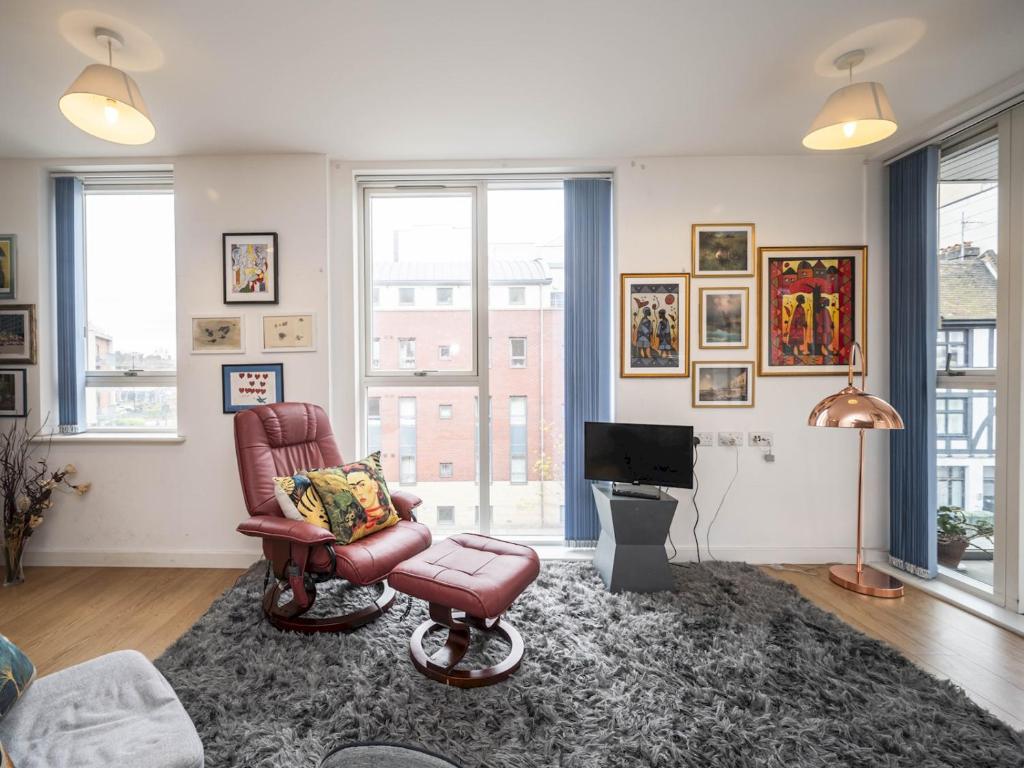 a living room with a chair and a television at London Apartment near Tower Bridge and Tube Pass the Keys in London