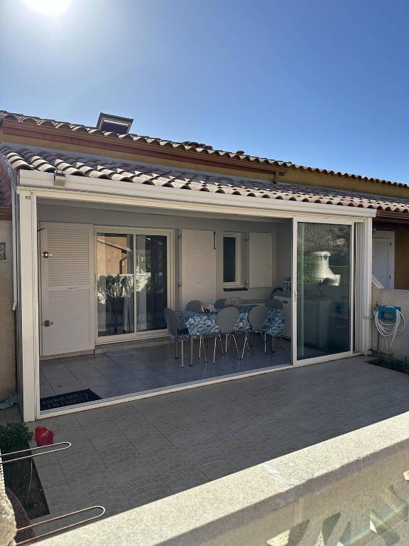 - un pavillon avec une table et des chaises sur la terrasse dans l'établissement HOLIDAYLAND 432 VILLA T2 MEZZANINE 6 couchages climatisé avec véranda et Box internet NARBONNE PLAGE, à Narbonne-Plage