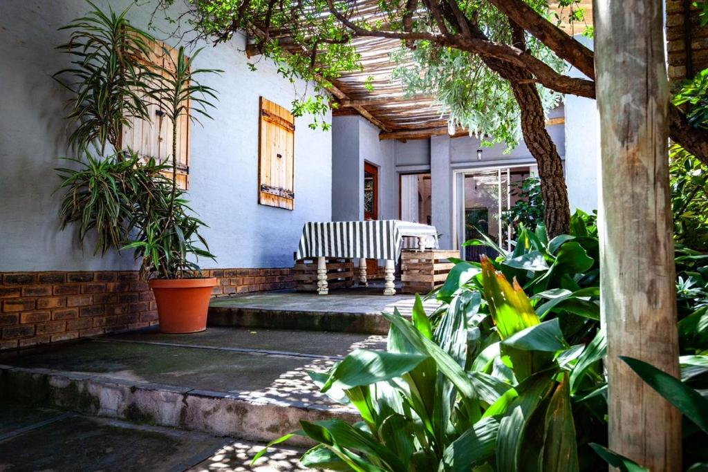 a porch of a house with a bench and plants at Waters on Willows in Pretoria