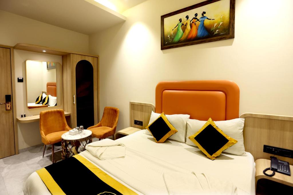 a hotel room with a large bed and chairs at Hotel A R Paradise in Mire