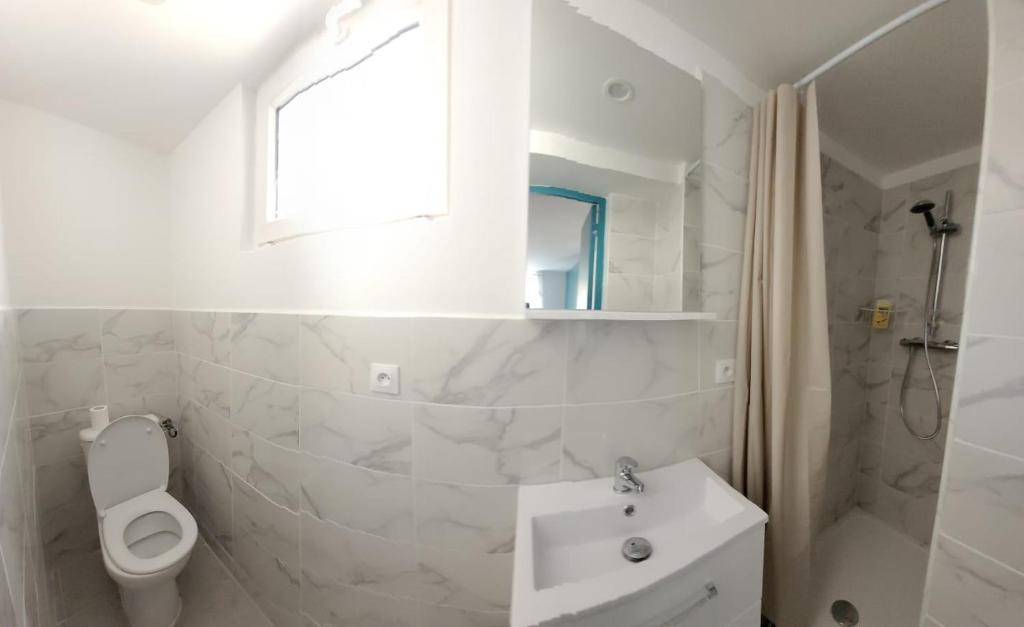 une salle de bain blanche avec des toilettes et un lavabo dans l'établissement Charment T2 quartier créateurs,Métro Crs julien., à Marseille