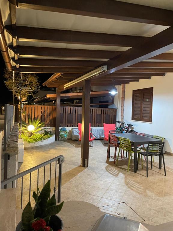 eine Terrasse mit einem Tisch und Stühlen sowie ein Esszimmer in der Unterkunft Belmare trilocale a piano terra indipendente in San Vito lo Capo