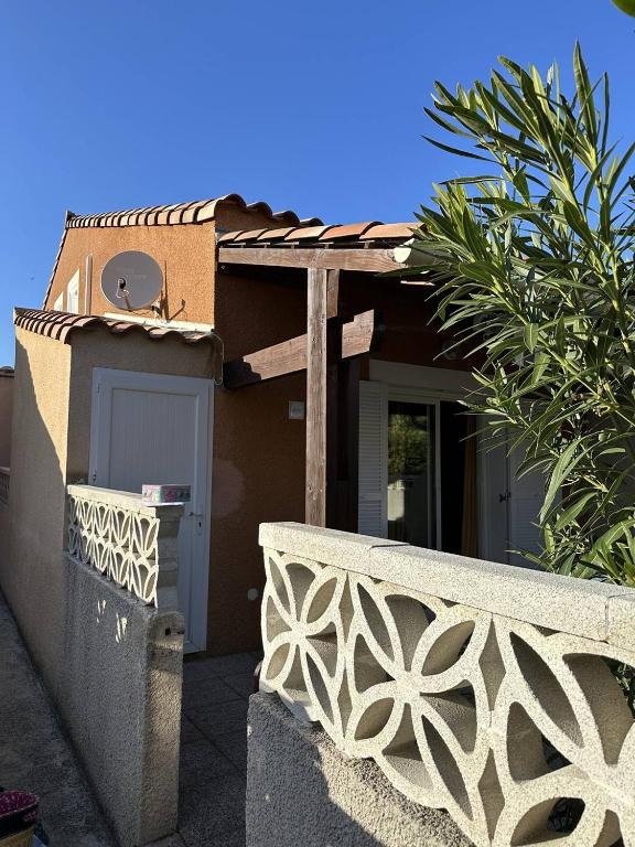 une maison avec un portail et une clôture dans l'établissement HOLIDAYLAND 420 VILLA T3 MEZZANINE 8 couchages climatisé NARBONNE PLAGE, à Narbonne-Plage