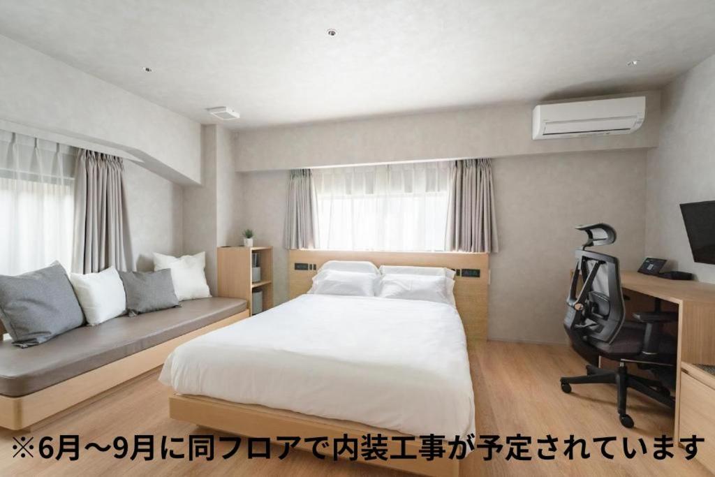 福岡市にある脈 -MYAKU PRIVATE SAUNA-のベッドとソファ付きのホテルルーム