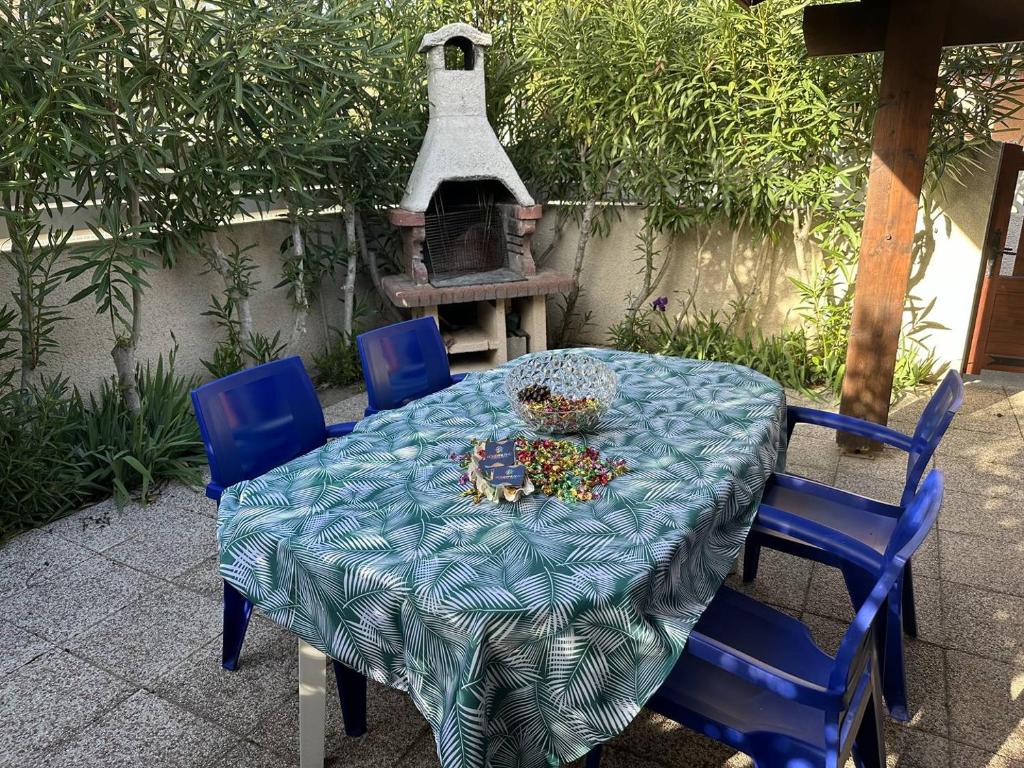 une table avec un chiffon bleu et des chaises bleues dans l'établissement HOLIDAYLAND 323 VILLA T2 MEZZANINE 8 couchages climatisé NARBONNE PLAGE, à Narbonne-Plage