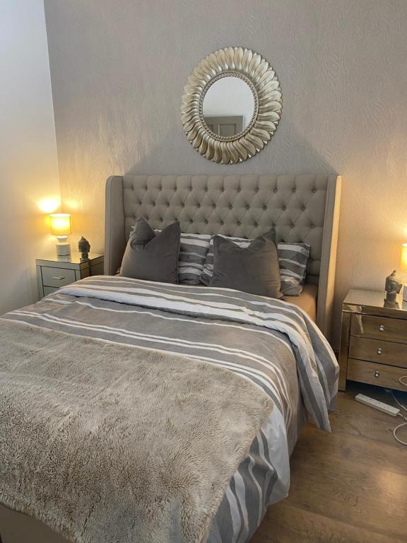 a bedroom with a large bed with a mirror on the wall at Beautiful Views Welsh Valley home in Mountain Ash