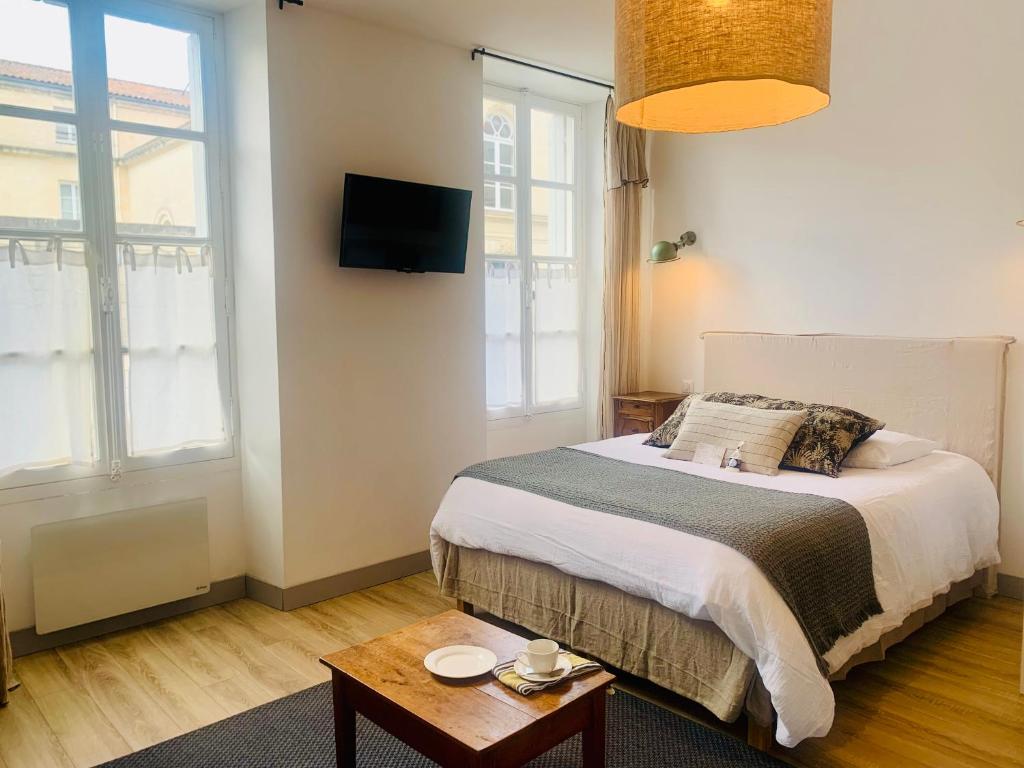 a small bedroom with a bed and a table at les appartements du 10 in Rochefort