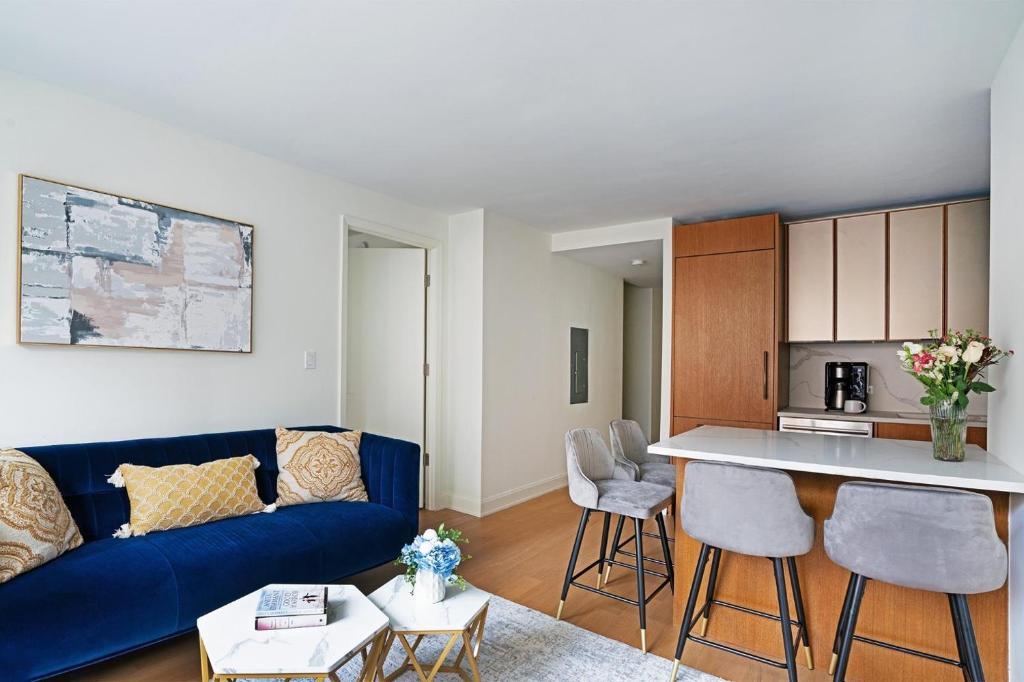 a living room with a blue couch and a kitchen at Luxurious 2 BR Apartment in New York in New York
