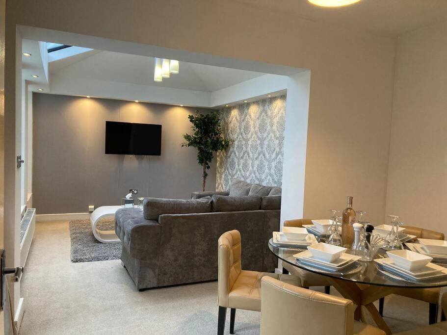 a living room with a couch and a table at Guest Homes - Hunters Wood Court in Euxton