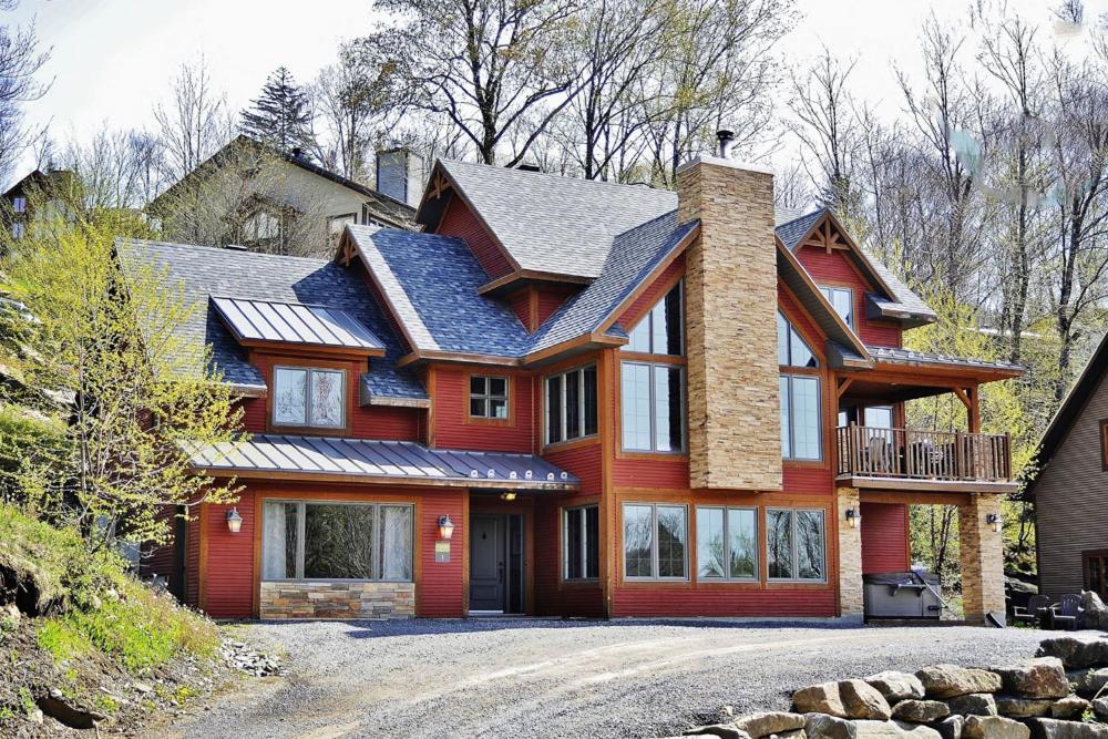 a large red house with a gambrel at Chalet 01 Chemin Blanc by Les Chalets Alpins in Stoneham
