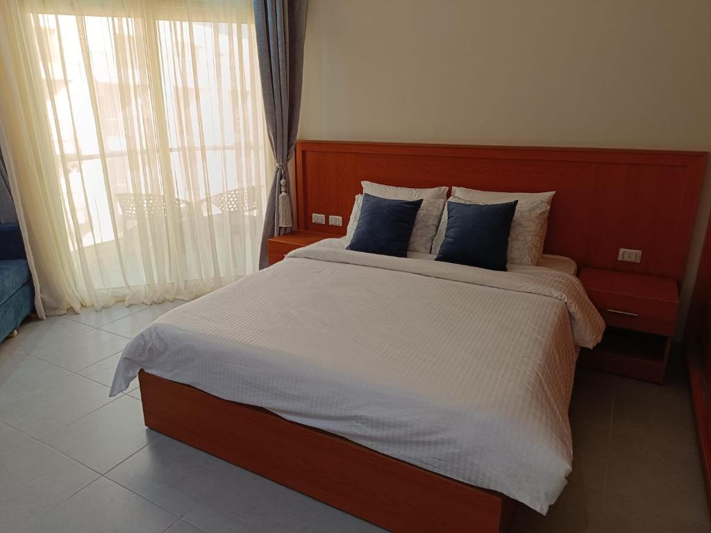 um quarto com uma cama grande e almofadas azuis em Scandic Resort Apartment B604 Hurghada em Hurghada