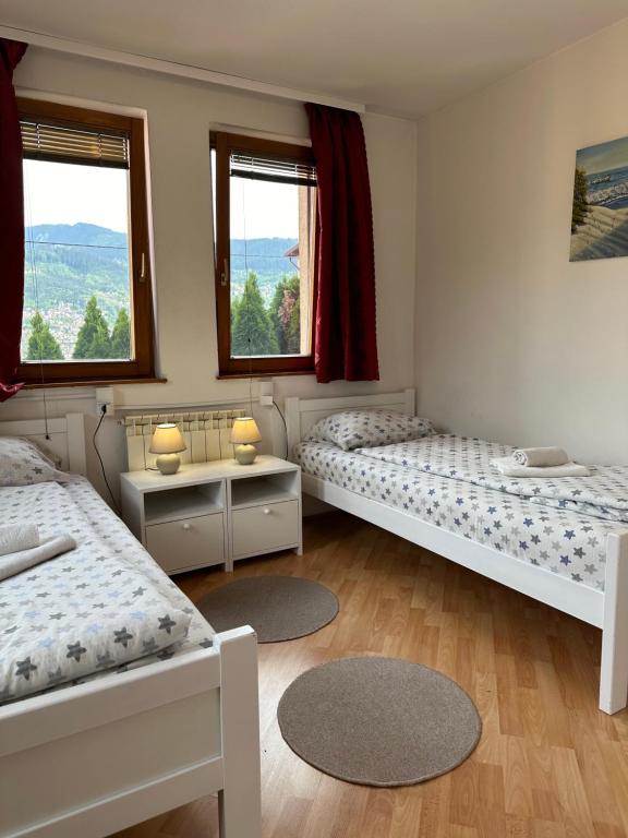 a room with three beds and two windows at One Love in Sarajevo