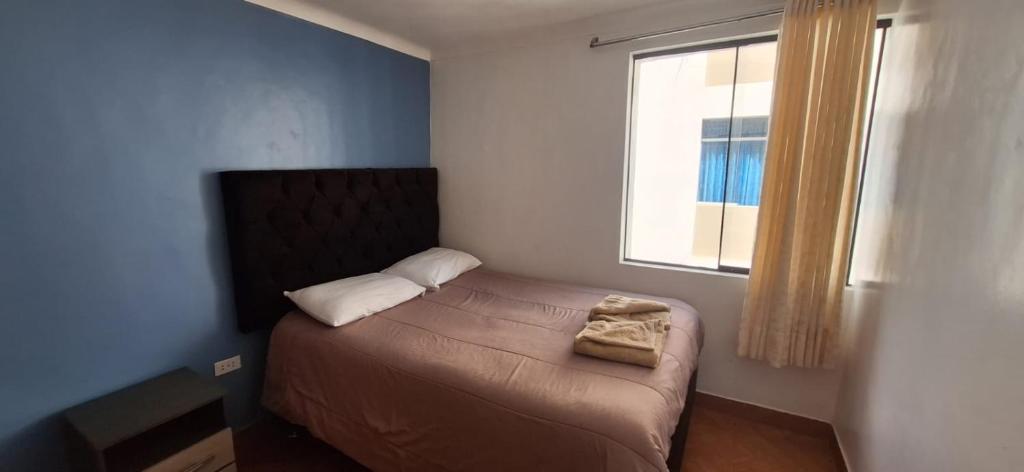 uma pequena cama num quarto com uma janela em Lucia's apartmens em Cusco