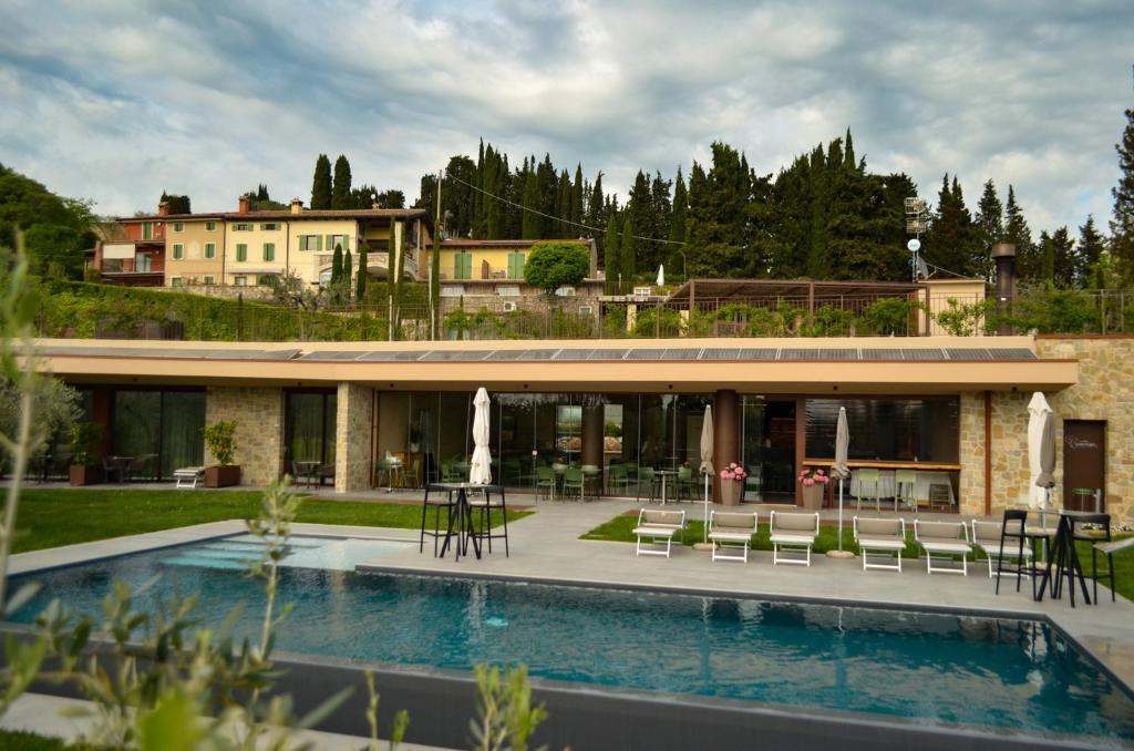 ein Haus mit einem Pool vor einem Haus in der Unterkunft La Cipressina B&B in Cavaion Veronese