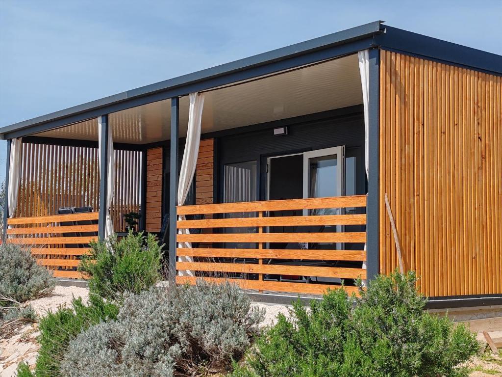 Casa moderna con un gran porche de madera en la parte delantera. en New! Mobile Home Domina near the beach with shared pool, en Pirovac