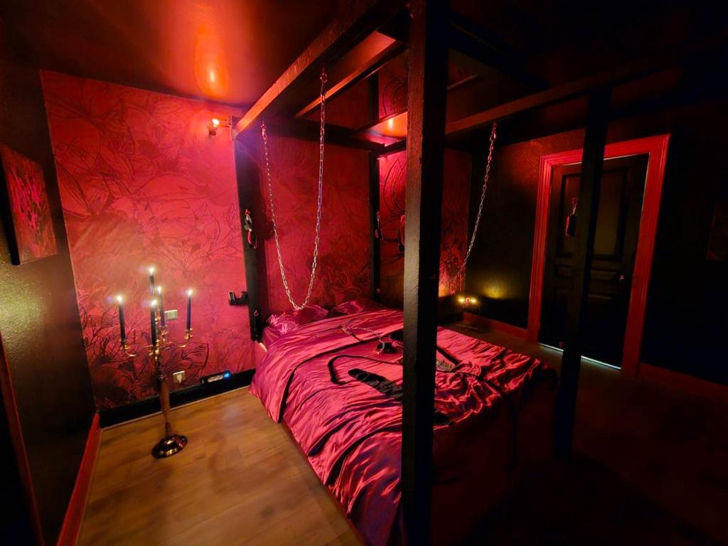 - une chambre avec un lit dans une chambre rouge dans l'établissement Le Donjon de Mulhouse, à Mulhouse