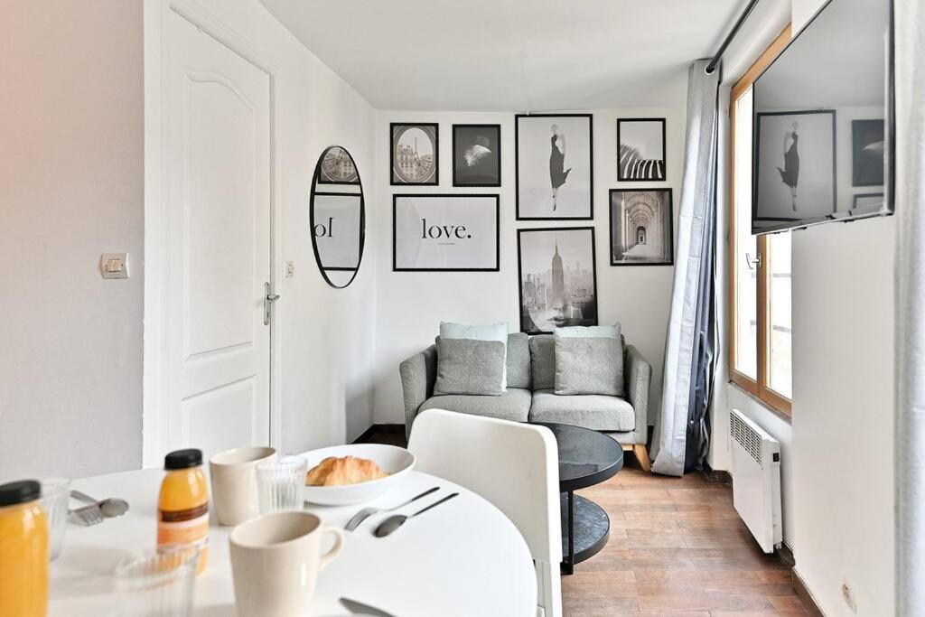 un salon blanc avec une table et un canapé dans l'établissement Appartement paisible et central Rivoli, à Paris
