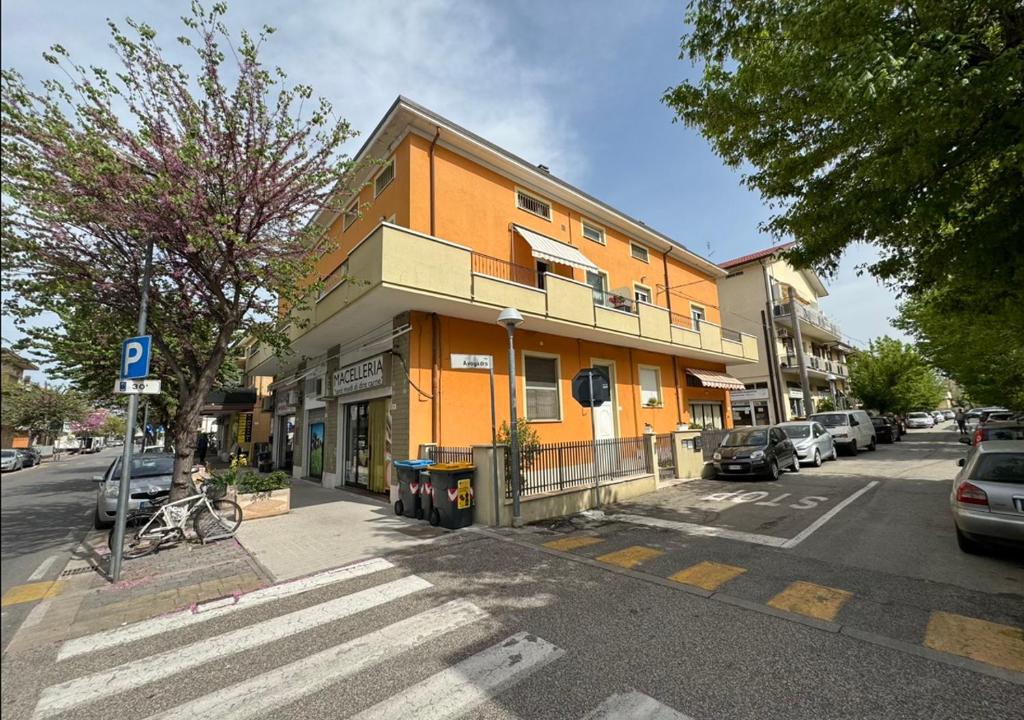 an orange building on a city street with cars parked at Dimora Mariagrazia in Rimini
