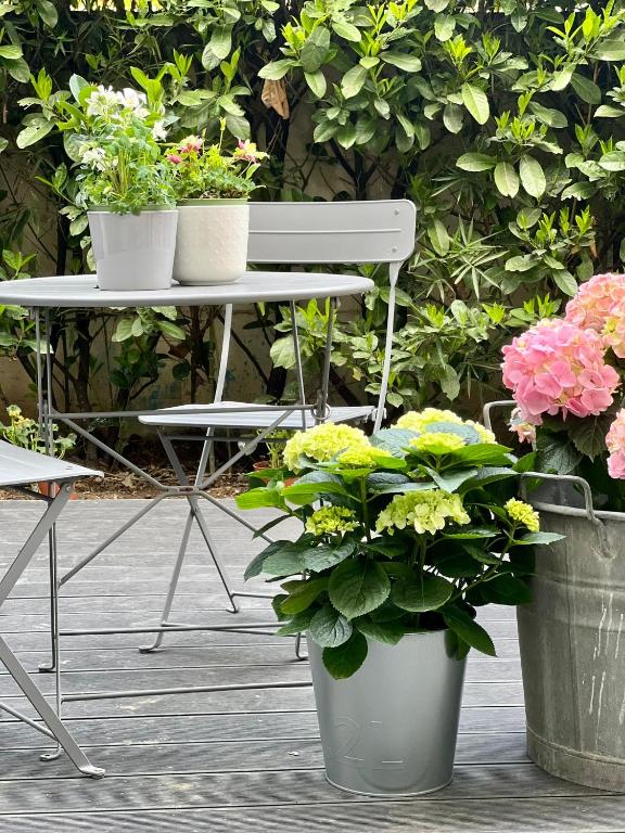 a table with three potted plants and a white chair at Loft G Hospitality in Milan