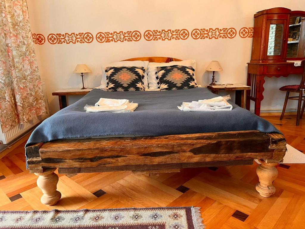 a bedroom with a large wooden bed with blue sheets at Dabakhnebi in Telavi