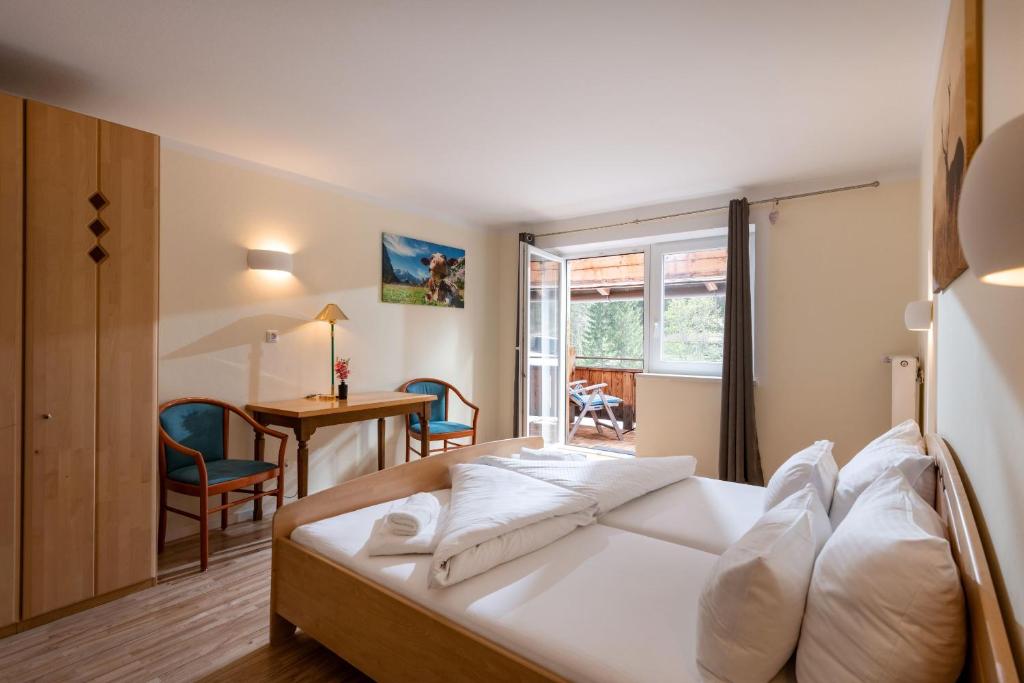 een slaapkamer met een bed en een tafel en stoelen bij Aktivurlaub, Wandern, Biken und Baden in Tirol, FeWo 13 in Thiersee