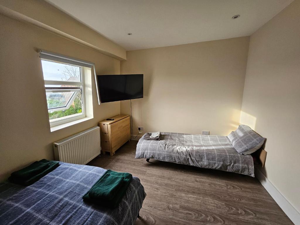 ロンドンにあるImpeccable 1-Bed Apartment in Londonのベッド2台、薄型テレビが備わる客室です。