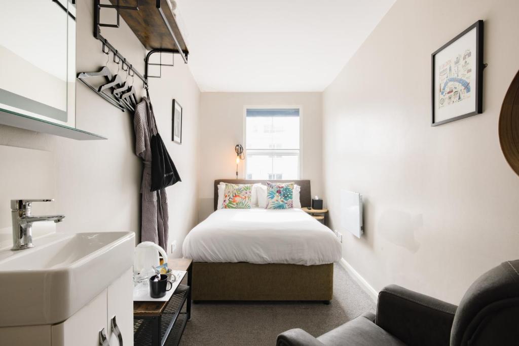 a small bedroom with a bed and a sink at Borough High Street Rooms in London