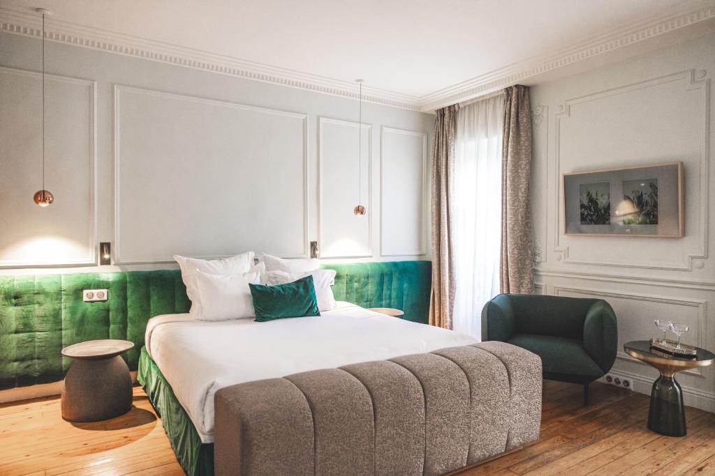 une chambre d'hôtel avec un lit et une chaise dans l'établissement Hôtel Singulier Bordeaux, à Bordeaux