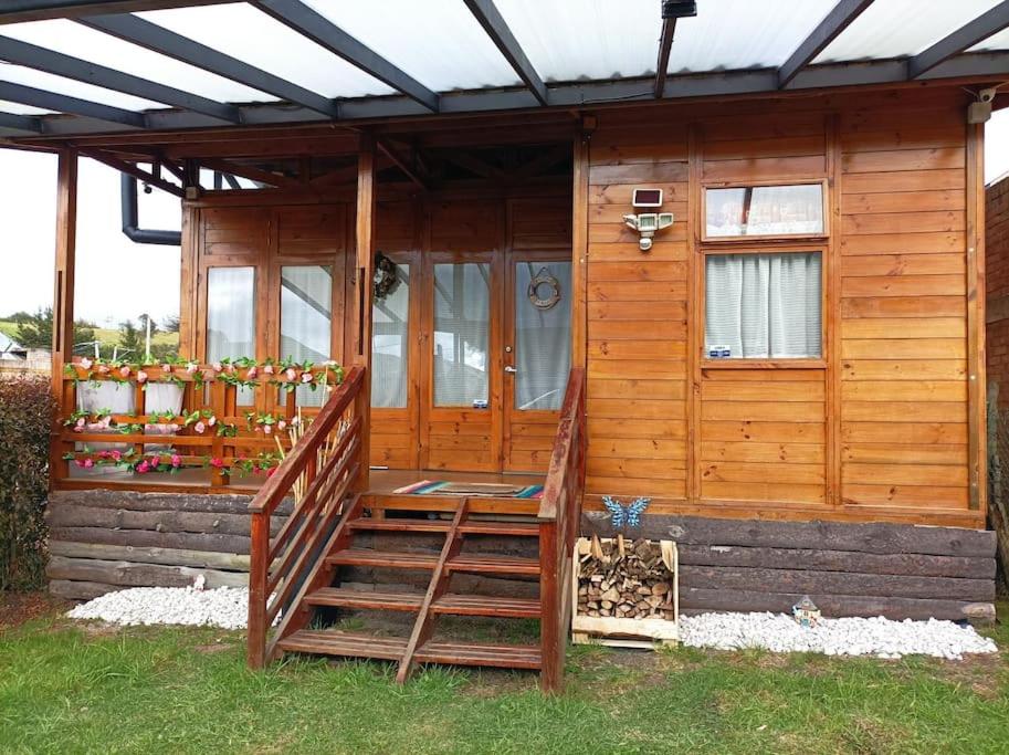 Cabaña de madera con escalera que conduce a un porche en Romantic Cabin Home ! en Bogotá