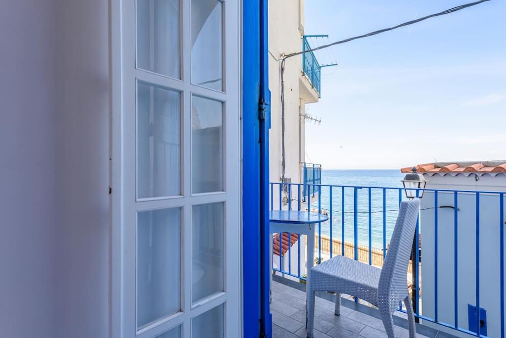 uma porta para uma varanda com uma cadeira e o oceano em Appartamento Relais sul mare 6 ospiti em Meta