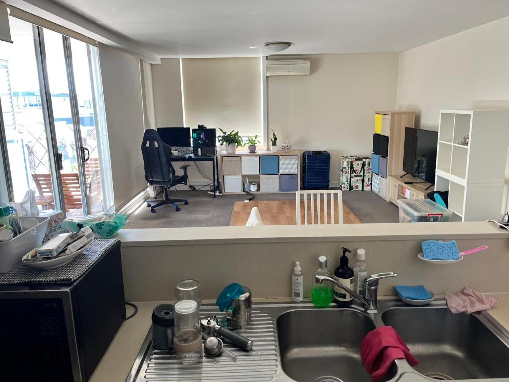 uma cozinha com um lavatório e uma sala de estar em B em Sydney
