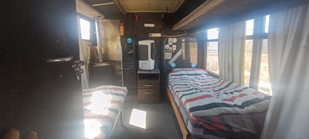 a small room with two beds in a train at BusTel Hostel en Bus in Potrerillos
