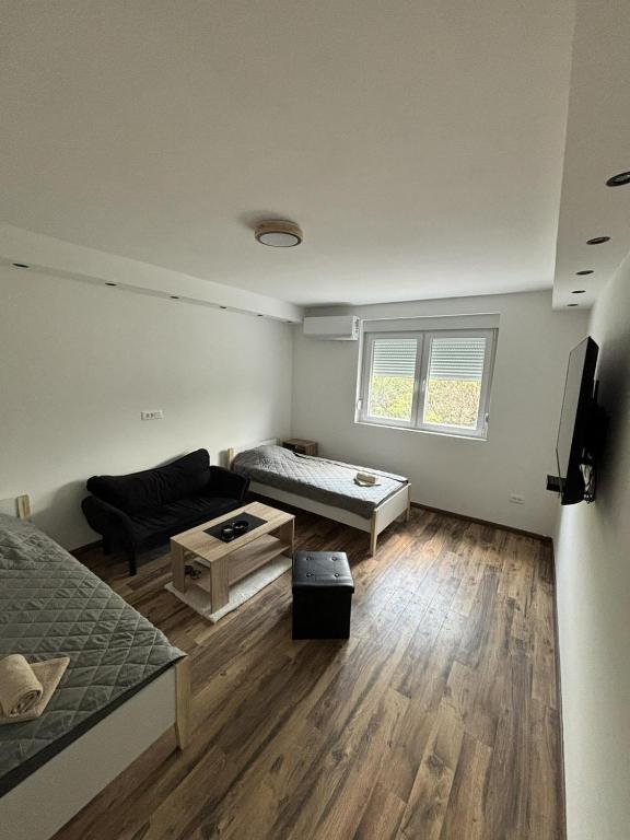 sala de estar con cama y sofá en Apartman Centar en Kuršumlija