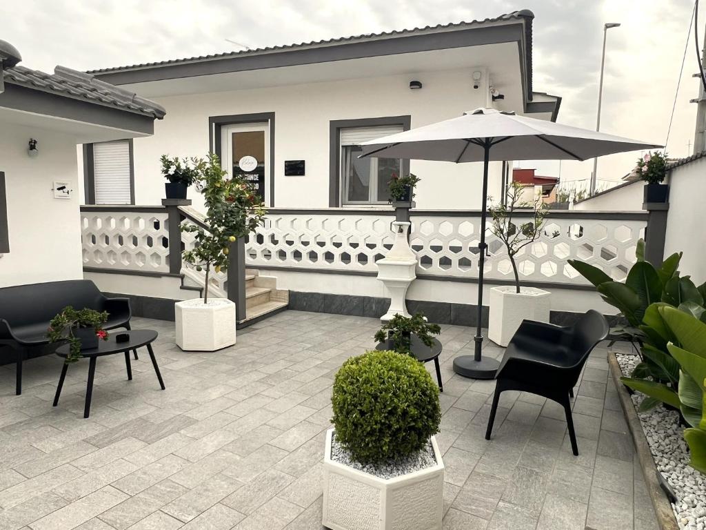 patio con sedie e ombrellone su casa di Kalasó Design Guest House a Fiumicino