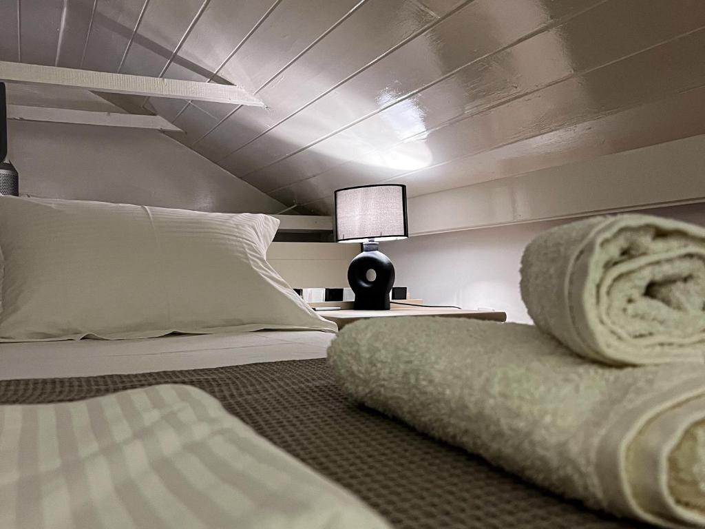 a bedroom with a bed and a lamp on a table at Pearl House in Hydra