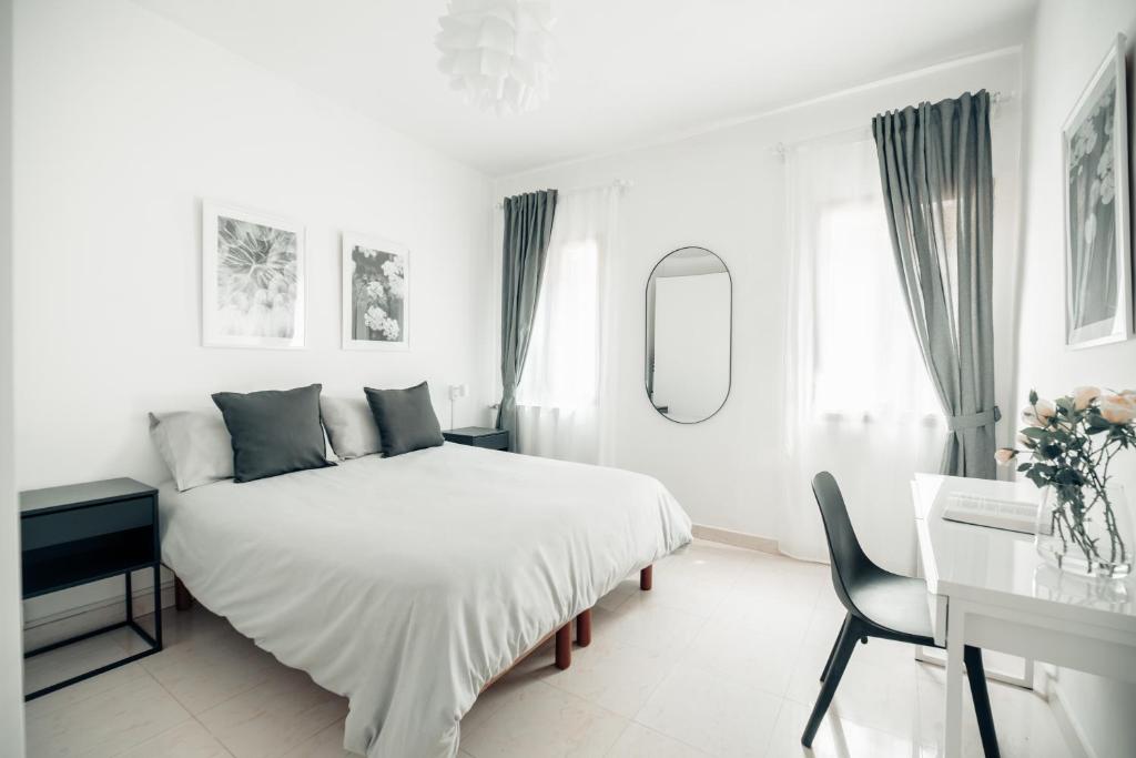 Un dormitorio blanco con una cama y un escritorio. en Cà Zorzi - 2 minutes from Biennale & Canal view - APE G, en Venecia