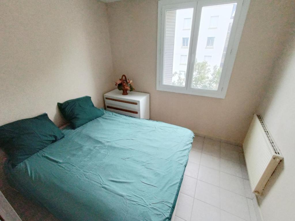 Un dormitorio con una cama azul y una ventana en Magnifique T2 avec double séjour, en Aviñón