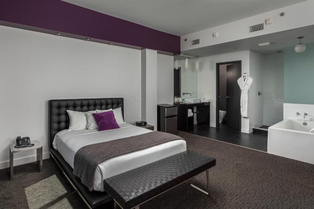 a bedroom with a large bed and a bath tub at Hotel Metro in London