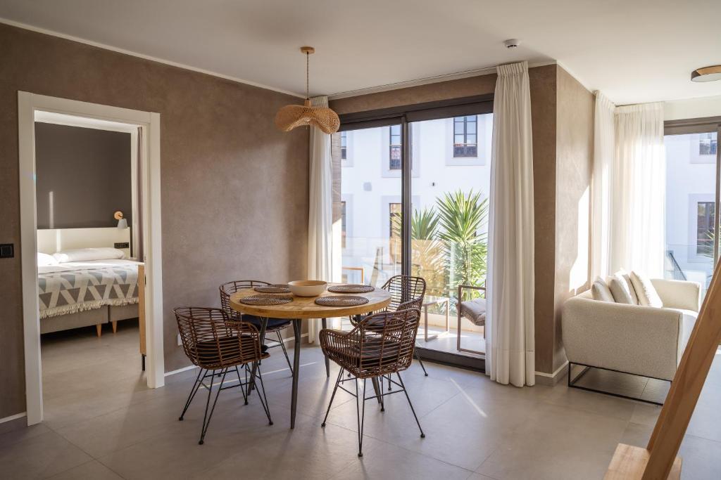 a dining room with a table and chairs and a bedroom at Apartamentos Las Indianas in Nueva de Llanes